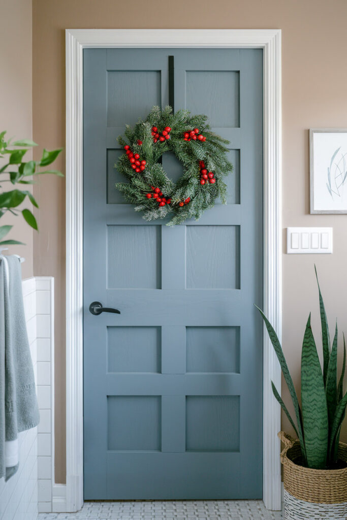 blue bathroom door adorned with a festive wreath Christmas decor idea