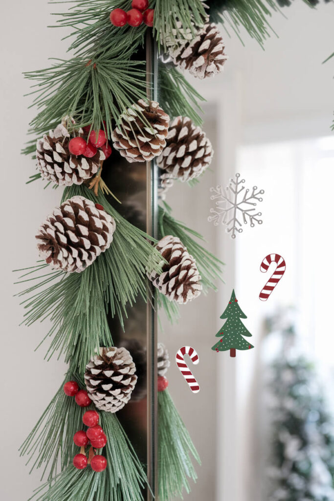 bathroom mirror with a faux pine garland and festive peel and stick decals