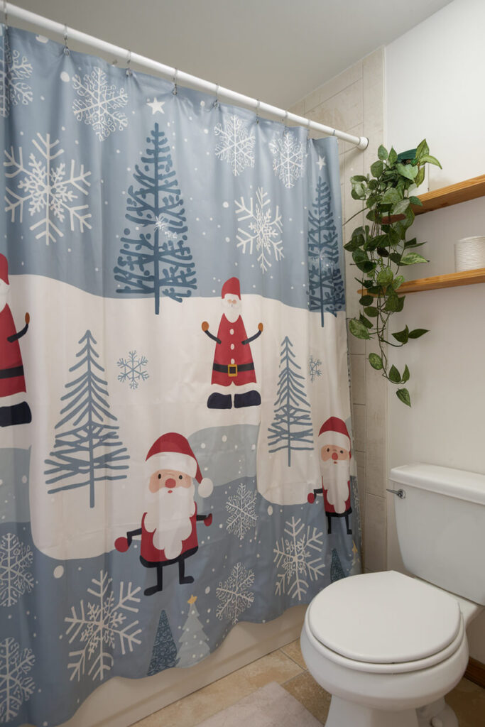 bathroom with a holiday themed shower curtain Santa, Christmas trees