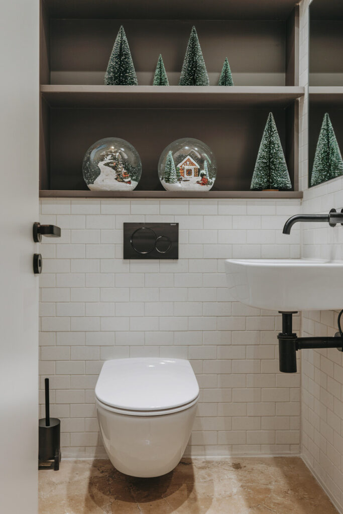 contemporary bathroom with white tiles snow globes decorations on the shelves of truffle brown color