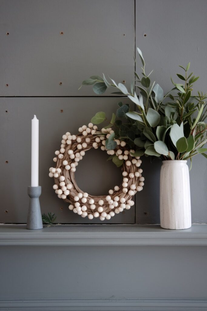 minimalist Nordic Christmas mantel decor wreath with white beads and magnolia in the white vase