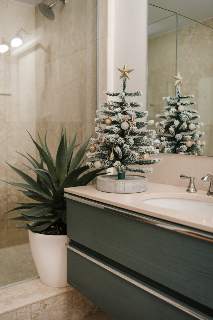 modern bathroom with an artificial mini Christmas tree with small ornaments on the vanity countertop