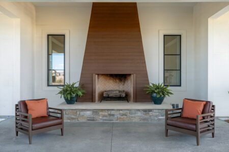 colors that go with brown, modern house outdoor living space with a brown fireplace, brown outdoor chairs, and white walls