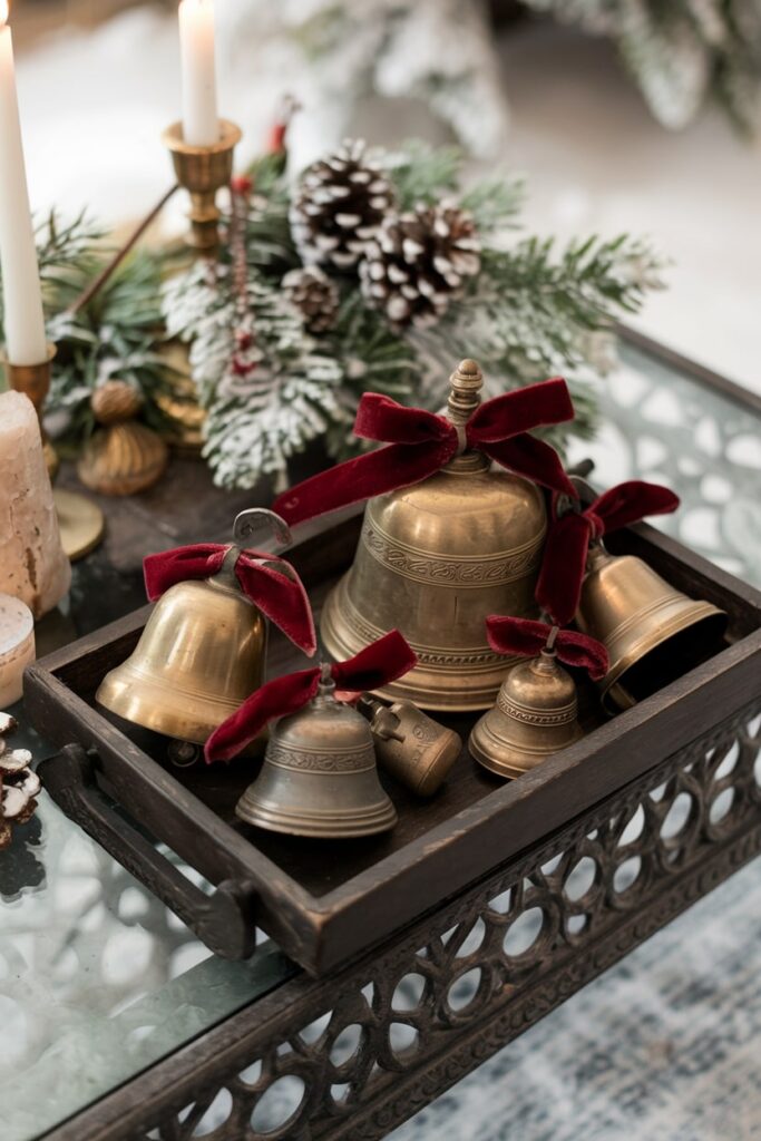 vintage brass bell collection with red velvet ribbons in the dark wooden tray on the Christmas coffee table