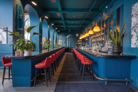 blue bar interior with red bar chairs
