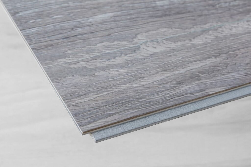 gray vinyl flooring plank with wood print, locks close shot, LVP