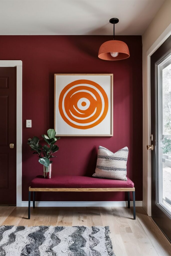 modern maroon color entryway with burnt orange artwork, maroon entryway bench