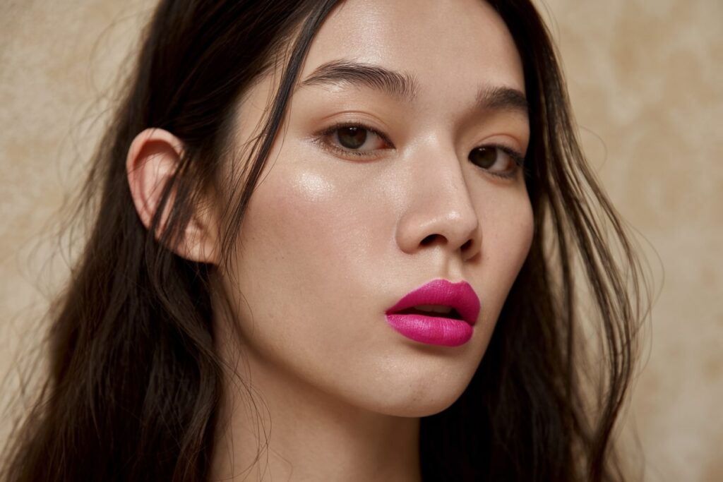 a close up photo of a female model's face, pink lips