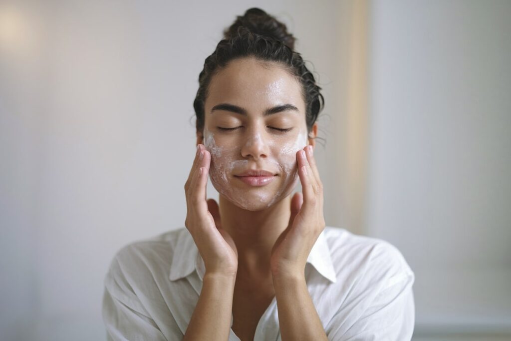 female model washes her face with a facial wash