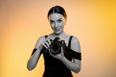 professional female photographer holding a camera, vibrant background
