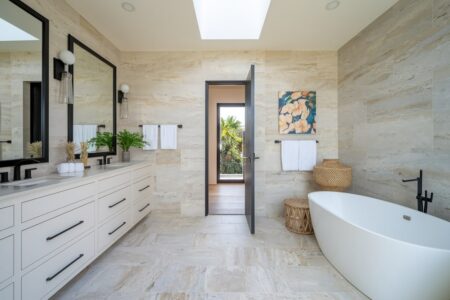 modern bathroom with beige tile and summer decor, black fixtures