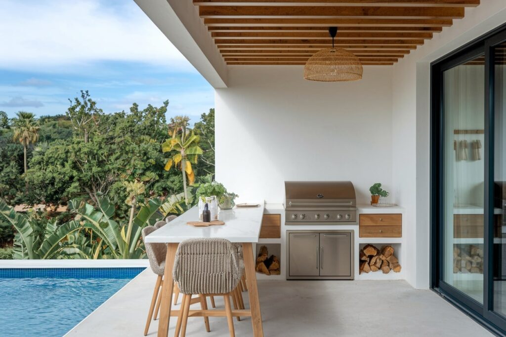 modern outdoor kitchen with grill near pool