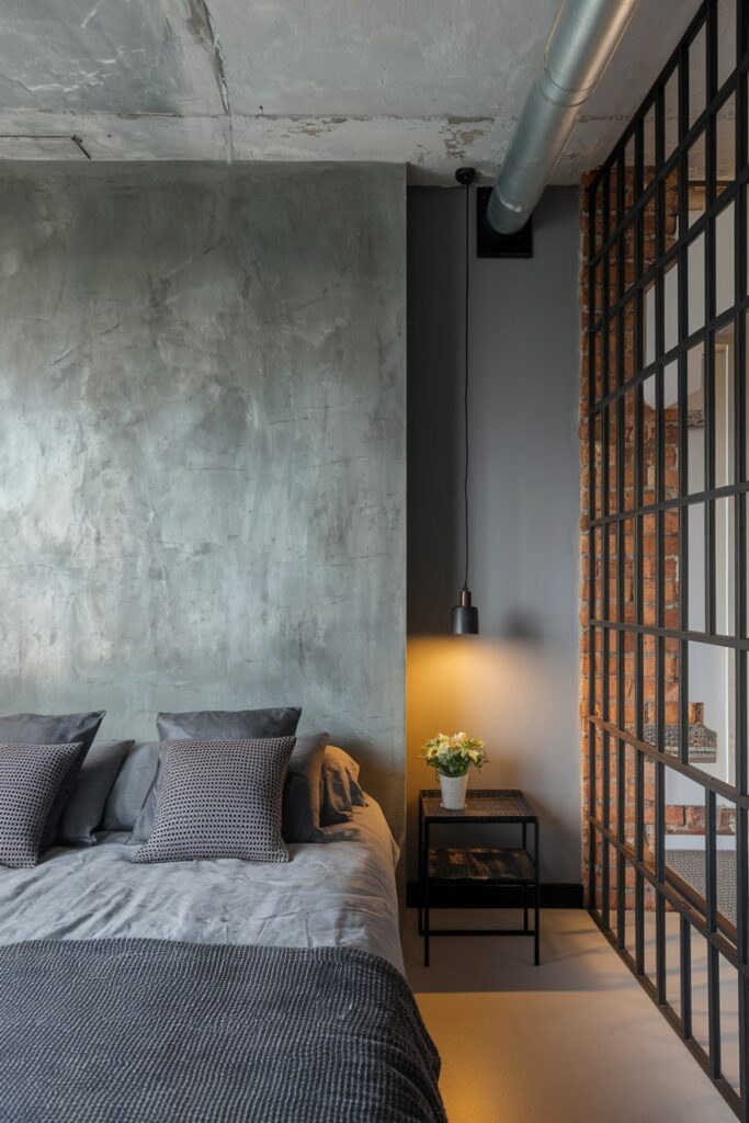 gray bedroom with concrete wall and ceiling, industrial aesthetic