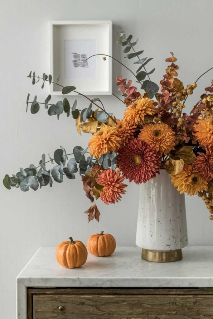 autumn flowers in a light ceramic vase on the console table as fall decor