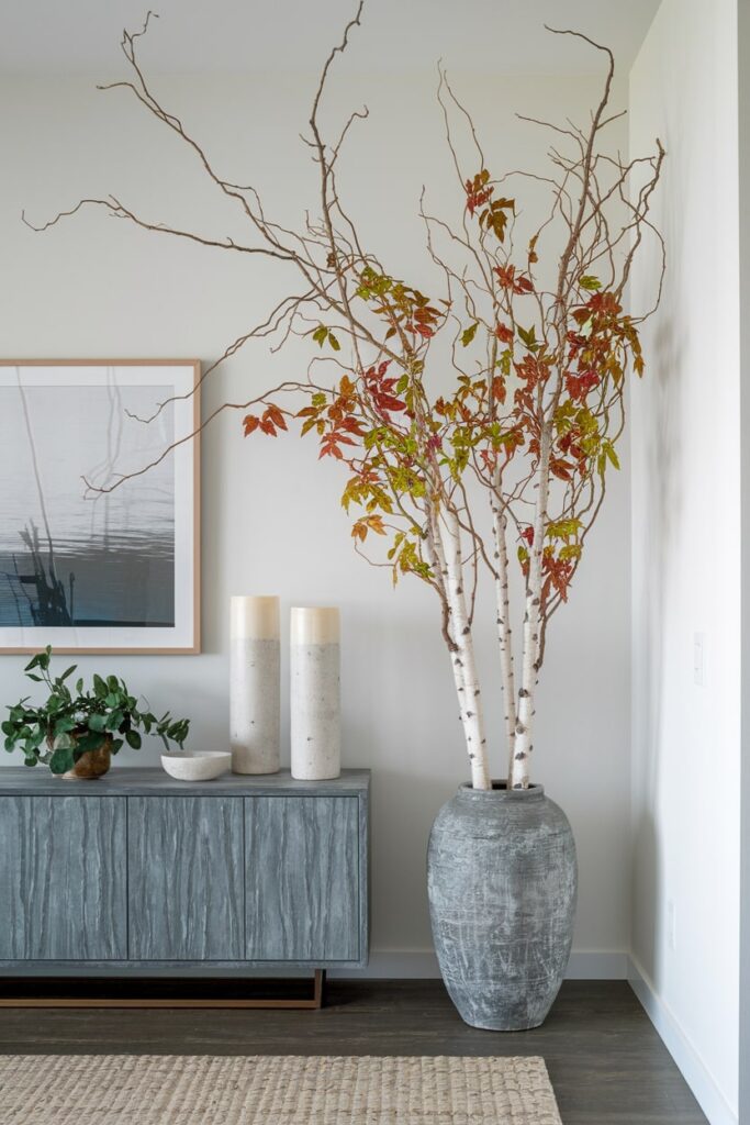 fall living room with white branches with colorful leaves in tall vase near console table
