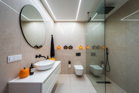 modern bathroom with Halloween decorations, black and orange pumpkins