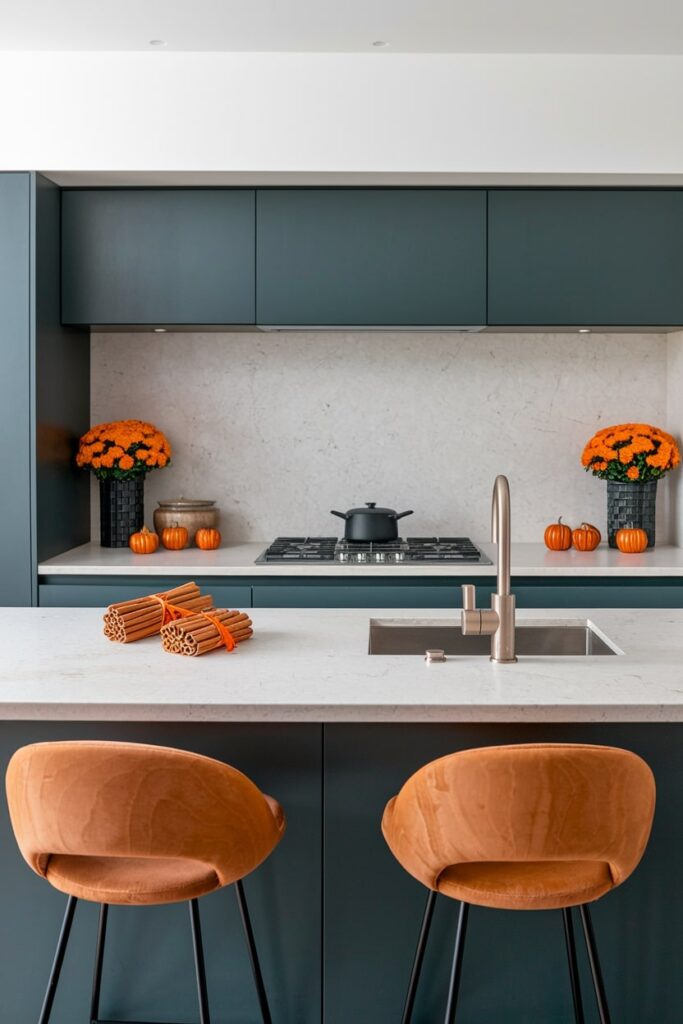 modern kitchen with orange flowers and cinnamon stick bundles tied with orange ribbons on the kitchen island