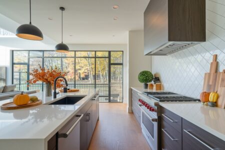 modern wooden kitchen with island, white backsplash, and fall decorations