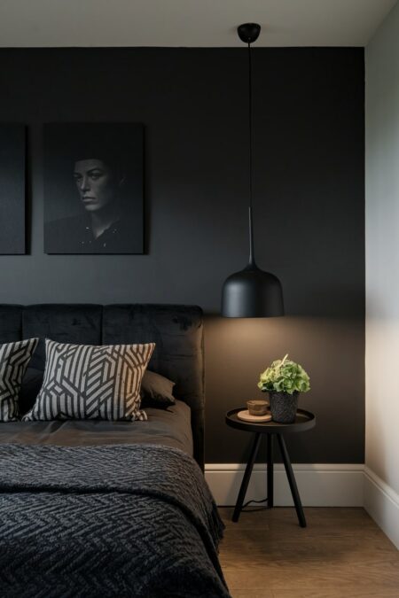 dark bedroom with black accent pendant lighting, black bed and bedding