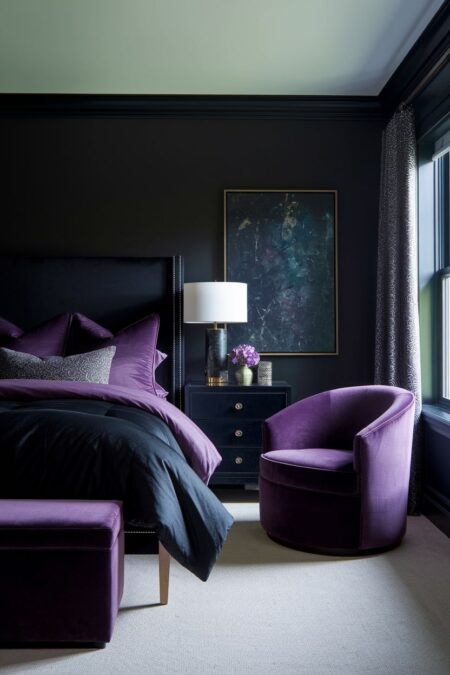 dark bedroom with black walls, dark purple bedding, curved armchair, and ottoman
