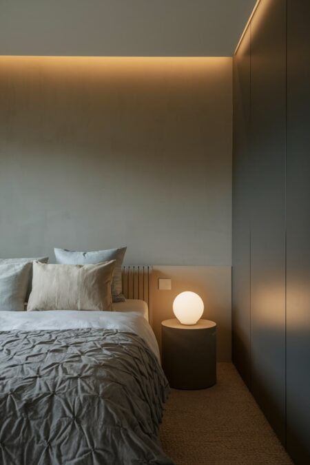 gray minimalist bedroom with layered ambient lighting and fitted wardrobe