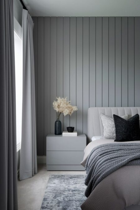 gray monochromatic minimalist bedroom with a dark charcoal accent pillow and decorative bowl