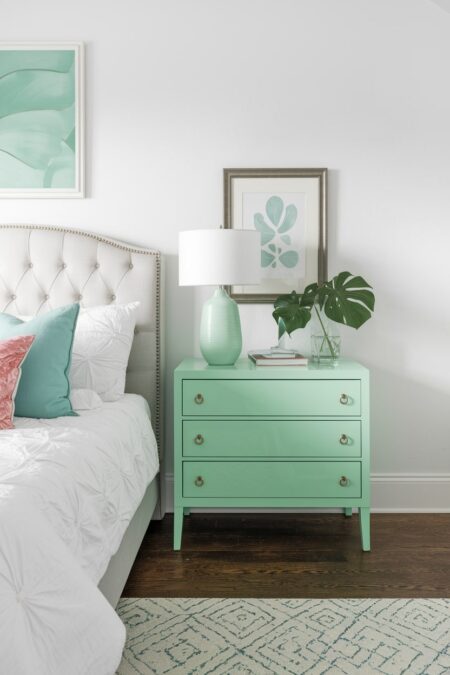 light bedroom with pastel mint green nightstand and decor