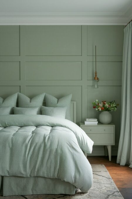 monochromatic sage green bedroom with colorful flowers in the vase