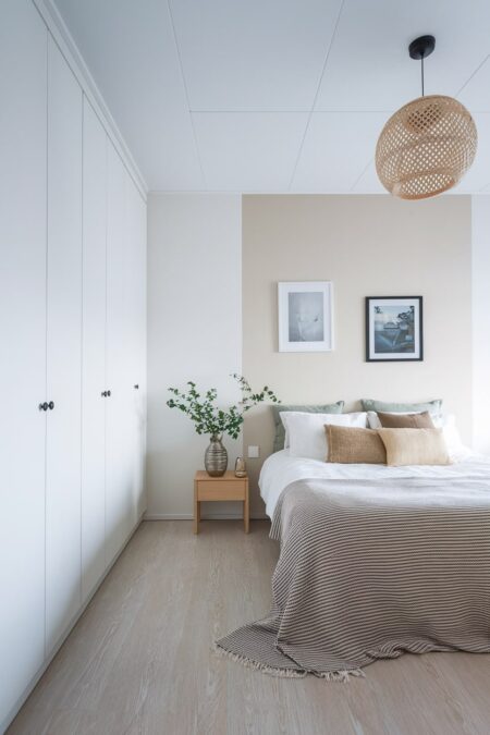 Scandinavian bedroom in a neutral color palette with a white built-in wardrobe