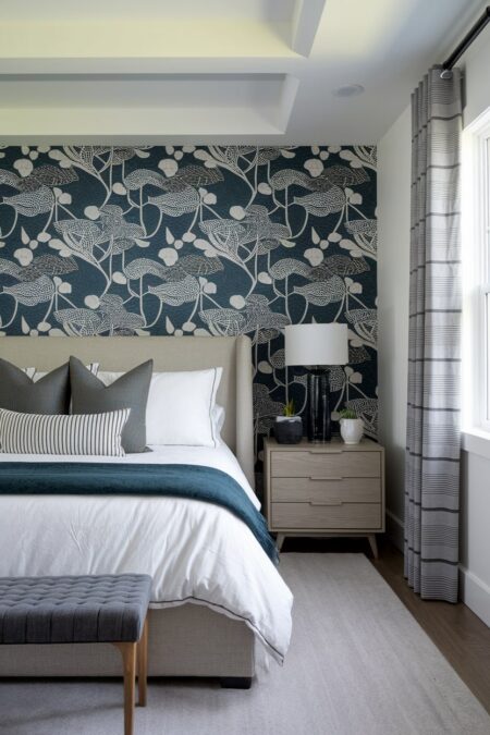master bedroom has an accent wall with a wallpaper with botanical print on the dark blue base