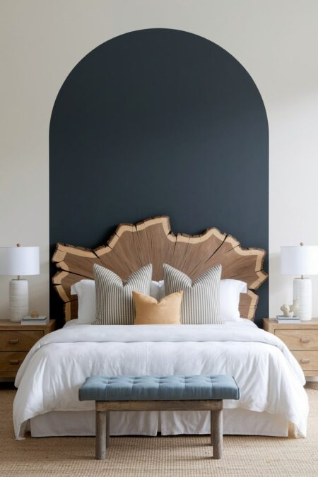 modern bedroom with a headboard made of the large slab of live-edge wood and dark large arch painted on the wall behind the bed
