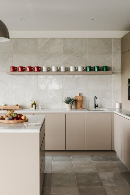 modern beige kitchen with festive red, white, green mugs on the open shelf as Christmas decor