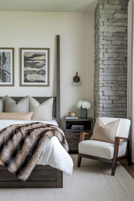 rustic bedroom with faux fur throw on the bed and stone wall accent