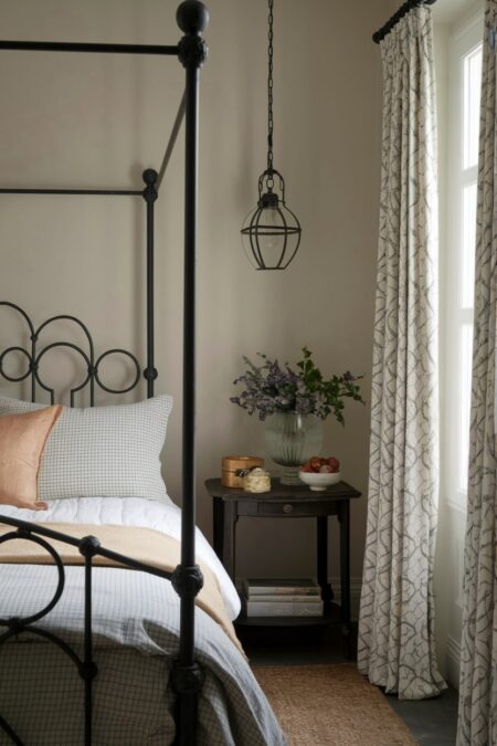 French country bedroom with a wrought iron bed frame and pendant light