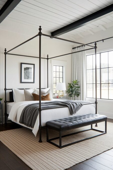 industrial bedroom with a black iron four-poster bed, white shiplap ceiling, and black leather bed bench