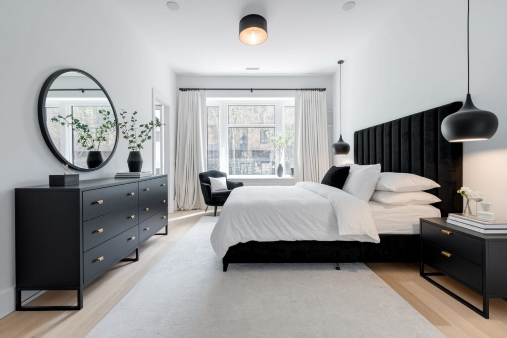 modern black and white bedroom with black furniture, velvet bed frame, white walls, curtains, and bedding