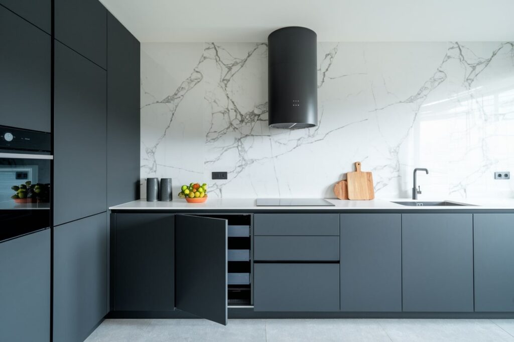 dark gray modern kitchen with a marble backsplash and smart storage solutions in the cabinets