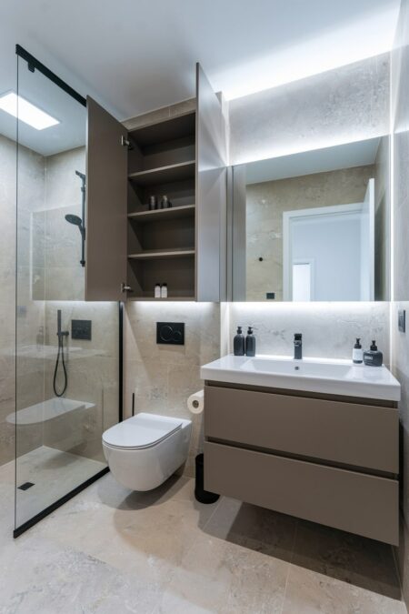 modern bathroom with a brown over the toilet built-in cabinet
