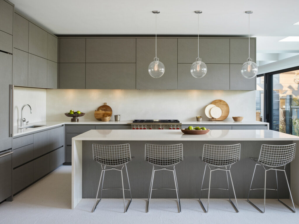contemporary kitchen with gray flat-panel cabinetry, white quartz countertops, and glass globe pendant lights