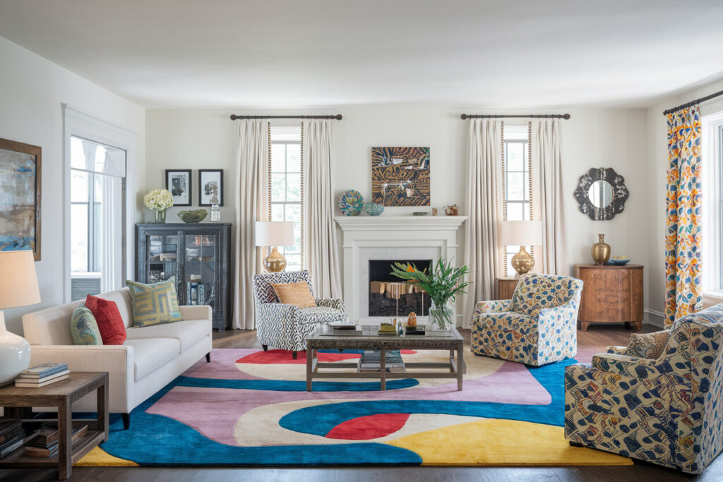 eclectic living room with fireplace white walls, colorful area rug, various textile patterns