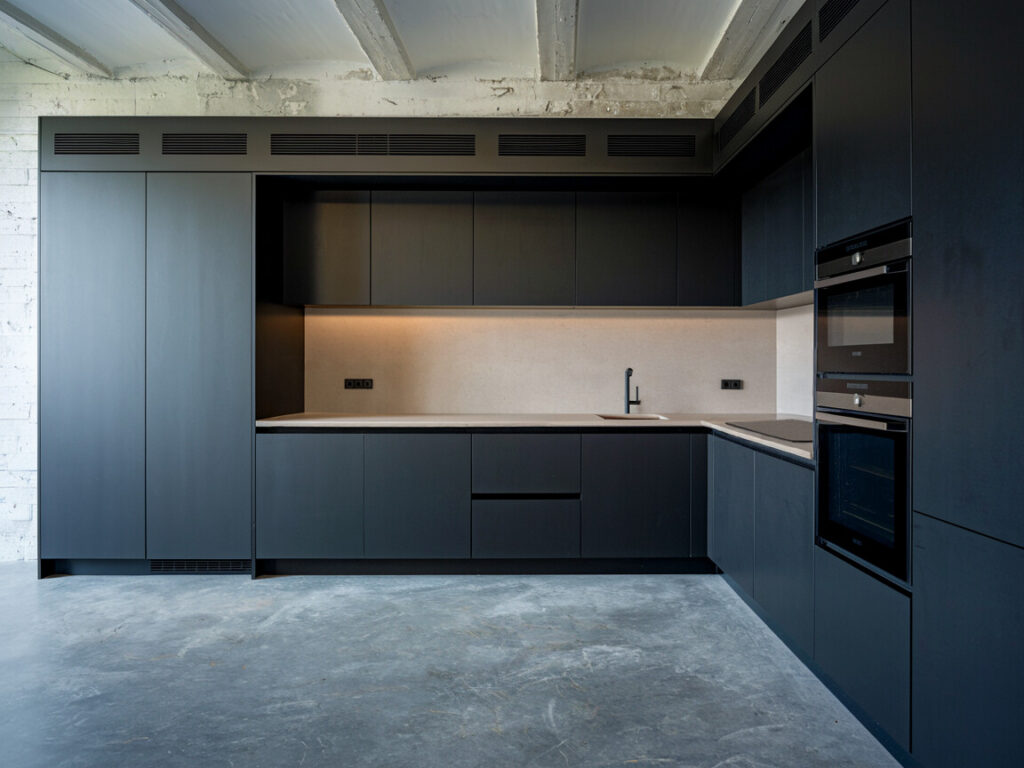 industrial minimalist kitchen with polished concrete floors and matte black cabinetry