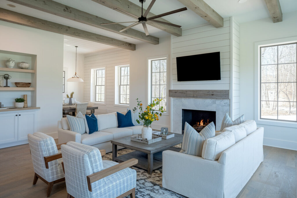 light open plan modern rustic style living room with exposed ceiling beams, fireplace, and TV