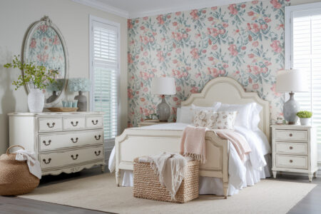 shabby chic style bedroom with floral wallpaper, distressed furniture, and gray ceramic table lamps