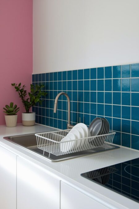 small kitchen with blue backsplash and white over-the-sink drying rack