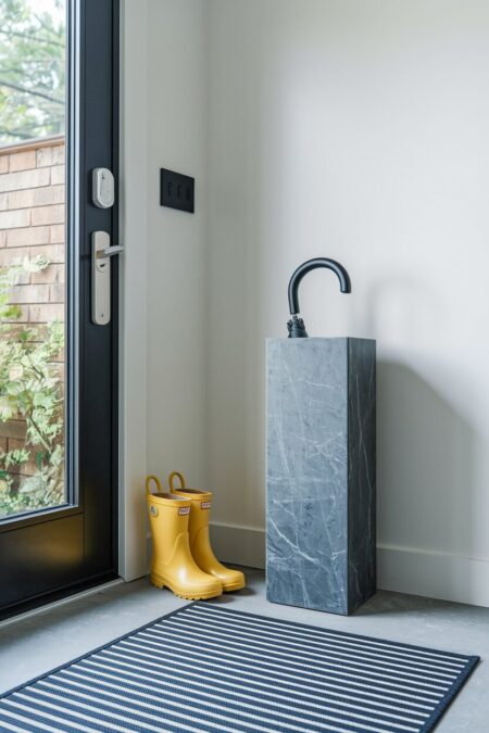 yellow rain boots and sleek umbrella stand as spring entryway decor