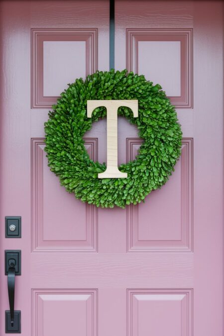 boxwood summer wreath with a T letter on the pink front door