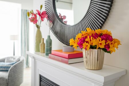 gold-painted vase with yellow and pink flowers as summer mantel decor