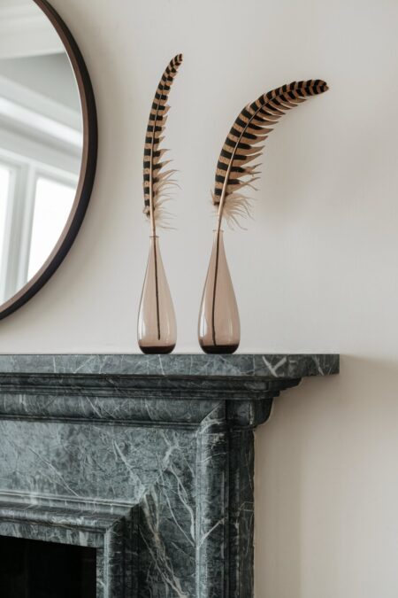 single feathers in the thin glass bud vases as summer mantel decor