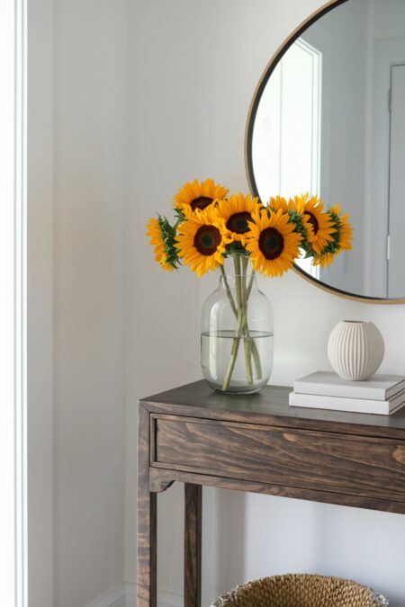 sunflowers in the glass vase on the console table as summer entryway decor