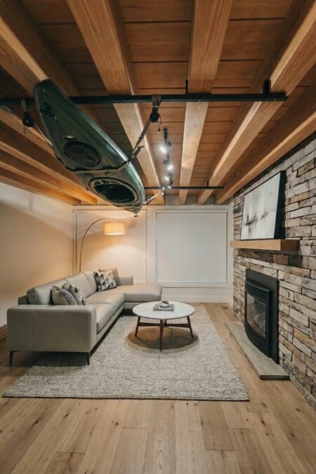 ceiling-mounted rack with a kayak in the finished basement